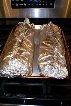 two pieces of foil sitting on top of an oven