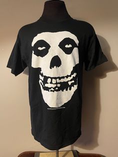 "Vintage Misfits Shirt  - 2004 Cinder Block licensed  - Big graphic design  - Crimson Ghost face  - Misfits spell out back graphic - Double stitched - Alstyle tagged  Size: L 21\" pit to pit  30\" shoulder to waist  Great vintage condition No rips or holes No stains" Alternative Style Fan Merchandise Shirt With Screen Print, Alternative Style Skull Print Tops For Fan Merchandise, Alternative Style Skull Print Top For Fans, Band Merch Shirt With Logo Print, Grunge Style Fan Merchandise Shirt With Screen Print, Grunge Graphic Print Shirt For Fans, Alternative Cotton Shirt For Fan Merchandise, Alternative Cotton Shirt For Fans, Alternative Style Cotton Shirt For Fans