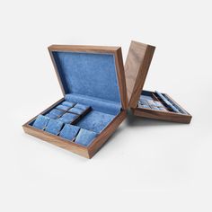 an open wooden box with blue velvet squares inside