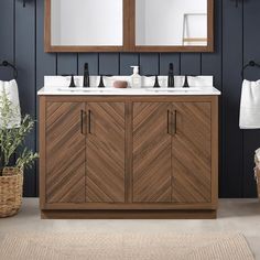 a bathroom vanity with two mirrors above it and a rug on the floor next to it