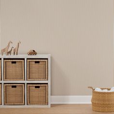 an empty room with four baskets on the floor and a wallpapered wall behind it