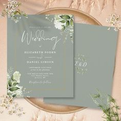 two wedding cards with flowers and greenery on them