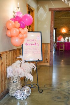 a welcome sign and some balloons in a room