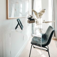 a chair sitting in front of a window next to a plant