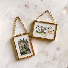 two framed pictures hanging on a wall next to each other, one with a house and the other with a dog