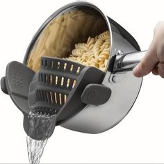 a person is pouring pasta into a pot with the lid open and it's spouting out