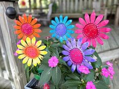 colorful flowers are sitting in a pot on the porch