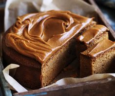 a loaf of cake with peanut butter frosting in a wooden box on a table