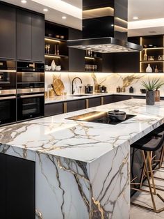 a large kitchen with marble counter tops and black cabinets, along with bar stools