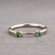 a ring with two green stones on it