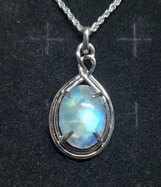 "Very Nice Blue, Green And Gold Flash Moonstones Available In Beautiful Celtic Inspired 925 Sterling Pendant Rhodium Plated. Stone is approx 12x16mm. 18\" Sterling Chain. The Photos And Video Are An Example Of Type And Quality Of Available Stones. Stones Vary. Some Artifacts and Lines are Naturally Occurring in Moonstones. Chain Length Options By Messaging At Time Of Purchase. Great Gift! Gift Box  Included. *You May Request Desired Colors, And I Will Try To Send If Available!" Silver Necklace With Large Oval Cabochon Stone, Sterling Silver Necklace With Large Oval Stone, Oval Sterling Silver Necklace With Large Stone, Moonstone Gemstone Jewelry In Oval Cabochon, Sterling Silver Jewelry With Large Oval Stone Pendant, Sterling Silver Oval Necklaces For Jewelry Making, Oval Cabochon Moonstone Jewelry, Spiritual Silver Gemstone With Oval Pendant, Spiritual Silver Oval Pendant Gemstone