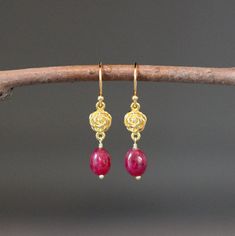 "Elegant smooth Red Ruby oval stones are wire wrapped with 18k gold vermeil pins onto 24k gold vermeil rose flower links. These dangle from 18k gold vermeil earwires. Choose from balled gold earwires (as shown and sent with stoppers for the ends of the wires) or plain 24k gold vermeil leverback earwires (these close in the back). Wonderful lightweight dangle earrings. The perfect go-to-earrings for any occasion. Gold flower links: 7x12mm Red Ruby stones: 7x8mm Total length of earrings: 1 3/8\" L Rose Gold Ruby Earrings For Gifts, Ruby Earrings In Yellow Gold For Gift, Ruby Yellow Gold Earrings For Gift, Yellow Gold Ruby Earrings For Gift, Single Ruby Earring As A Gift, Delicate Wire Wrapped Yellow Gold Earrings, Delicate Yellow Gold Wire Wrapped Earrings, Elegant Wire Wrapped Flower Earrings, Yellow Gold Ruby Dangle Earrings