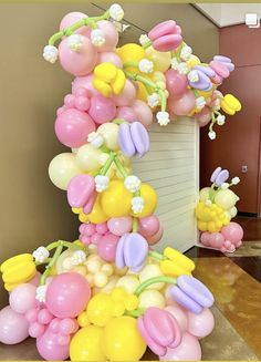 balloons and flowers are arranged in the shape of an eiffel tower on display