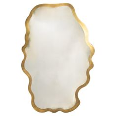 an oval shaped mirror with gold trimmings on the edges and bottom, against a white background