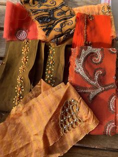 several different colored scarves on a wooden surface