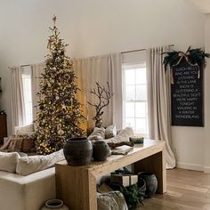 a living room filled with furniture and a christmas tree in the middle of the room