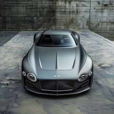 the front view of a silver sports car in an empty parking lot with concrete walls behind it