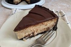 a piece of chocolate cheesecake on a plate with a fork next to the slice