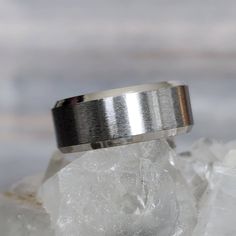 a silver ring sitting on top of a rock