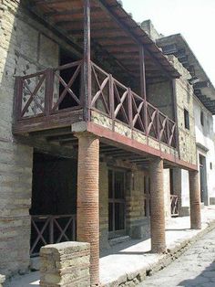 an old building with stone pillars and wooden balconies