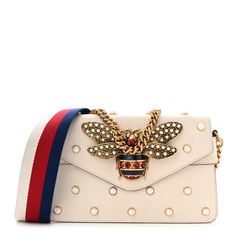 This is an authentic GUCCI Nappa Pearl Studded Mini Queen Margaret Broadway Shoulder Bag in Mystic White. This stylish shoulder bag is crafted of calfskin leather in off-white. The bag features a gold chain shoulder strap, an optional red, white, and blue web shoulder strap, and faux pearl detailing with a gold bee motif on the flap. The flap opens to a beige leather interior with a flat pocket. Queen Margaret, Gucci Crossbody Bag, Gucci Crossbody, Small Messenger Bag, Gucci Monogram, Gold Bee, Vintage Monogram, Stylish Shoulder Bag, Gucci Shoulder Bag