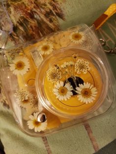 a plastic container filled with yellow and white flowers