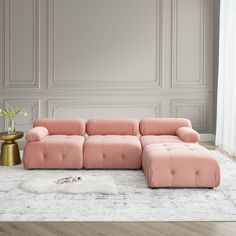 a pink couch sitting on top of a white rug