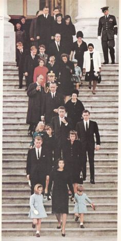 a group of people standing on top of steps in front of a building with columns