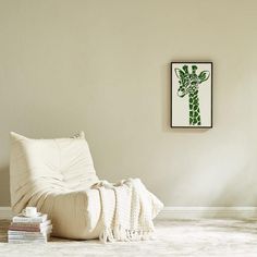 a living room with a white chair and pictures on the wall