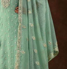 COLOR : Mint Green FABRIC : Top - Soft Organza, Bottom - Dull Santoon, Dupatta - Soft Organza WORK : Heavy Resham Embroidery, Zari, Sequins, Lace BorderOCCASION : Engagement, Party Wear, Festival READY-TO-WEAR : No STITCHING : Available as semi-stitched fabric, can be stitched using standard size option (+$20). Note: There might be a slight color variation due to lighting and flash used during photoshoot. The bright shade seen is the best closer view of fabric's color. Wedding Chanderi Sets With Intricate Embroidery, Wedding Sets With Intricate Embroidery On Chanderi, Wedding Sets With Intricate Embroidery In Chanderi, Unstitched Zari Work Suits For Reception, Embroidered Chanderi Sets For Wedding, Embroidered Dola Silk Sets For Wedding, Bollywood Style Suits With Traditional Drape For Weddings, Bollywood Style Wedding Suit With Traditional Drape, Traditional Bollywood Wedding Suits With Drape