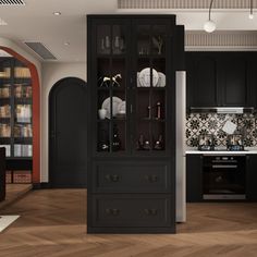 a black cabinet in the middle of a living room and kitchen area with white walls