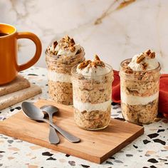 three mason jars filled with oatmeal and walnuts on a wooden cutting board