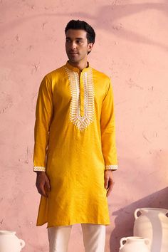 SHRESTHA BY VASTRAMAY Men's Yellow Silk Machine Embroidered Kurta Luxuriate in this vibrant yellow kurta, featuring intricate machine embroidery. Made from a silk blend, this kurta boasts a comfortable and stylish fit. Pair it with a dhoti or pajamas for a complete traditional look. Key Features Yellow silk blend with machine embroidery Mandarin collar Long sleeves Side slits Pockets Specifications Sleeve Length: Full Sleeves Top Shape: Straight Top Hemline: Straight Top Length: Knee Length Mate Festive Yellow Kurta With Intricate Embroidery, Yellow Chanderi Traditional Wear With Intricate Embroidery, Yellow Embroidered Kurta For Diwali, Chanderi Kurta With Gold Embroidery Long Sleeve, Yellow Kurta With Chikankari Embroidery For Diwali, Chanderi Long Sleeve Kurta With Gold Embroidery, Yellow Straight Kurta For Festivals, Yellow Straight Kurta For Diwali, Festive Yellow Kurta With Chikankari Embroidery