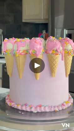 an ice cream cake with pink frosting and sprinkles is on a table