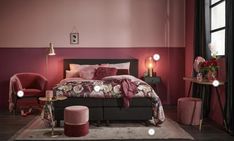 a bedroom with pink walls and furniture in the corner, along with a large bed