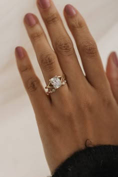 a woman's hand with a diamond ring on it