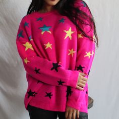 a woman wearing a pink sweater with stars on it