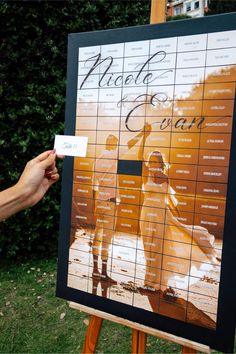 a person holding up a business card in front of a sign with people on it