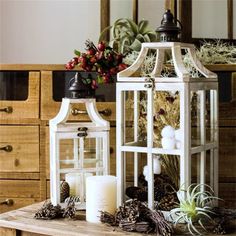 a table topped with candles and plants on top of a wooden table next to a mirror