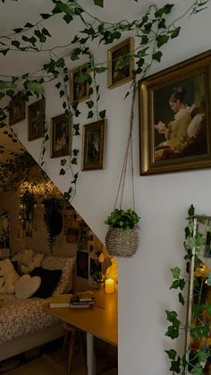 there are pictures on the wall next to the bed and plant hanging from the ceiling