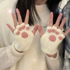 a woman wearing white gloves with pink flowers on it's fingers and hands in front of her face