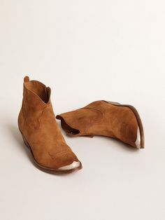 Young boots are a contemporary reinterpretation of the classic cowboy boot, feminized by the softened lines and high heel. Hand-crafted in leather decorated with cowboy-style stitching, this model features a cognac-colored suede upper and a toe in aged-effect silver-colored metal. The zip fastening on the side and gold-colored metal plaque engraved with the Golden Goose signature on the heel complete the look. The Golden Goose, Classic Cowboy, Engraved Plaque, Model Features, Leather Decor, Lace Socks, Cowboy Style, Cowboy Boot, Scarf Hat