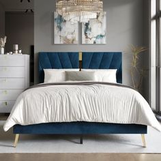 a bed with a blue headboard and white sheets