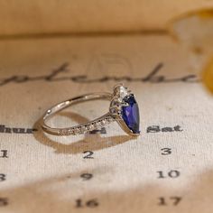 a blue stone ring sitting on top of a piece of paper