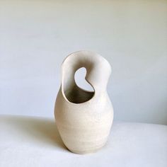 a white vase sitting on top of a table