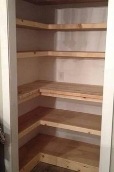 an empty pantry with wooden shelves in it