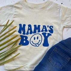 Mama's Boy (Blue Print On Natural/Cream Color) T-Shirt. Nwt. Small Business Created With A Great Quality T-Shirt And High Quality Screen Print. Sizes Available: 6 Mos, 12 Mos, And 24 Mos. T-Shirt: Rabbit Skins 100% Cotton Wash Instructions Included. Ready To Ship. Add A Few More Listings To Receive 15% Off Bundles Of 3 Or More! Cute Cream Tops With Letter Print, White Tops With Funny Print For Playtime, Playful Soft-washed Tops For Playtime, Cute Cream Cotton T-shirt, Playtime Soft-washed White Tops, Cream Summer Tops For Playtime, Cream Summer Playtime Top, Playful Cream Crew Neck Top, Cream Short Sleeve Top For Playtime