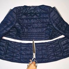 a pair of scissors are being used to cut the jacket