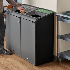 a man standing next to a trash can with his hand on the top of it