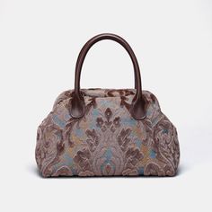 Embrace timeless elegance with our exquisite Victorian Carpet Satchel, a masterpiece meticulously crafted from rich burnout velvet for a luxurious and sophisticated touch. Designed with unique construction, this handbag stands on its own, effortlessly blending style with functionality. Crafted for enduring quality, the bag features genuine leather handles and a sturdy, heavy cotton canvas lining. Each purchase includes a detachable and adjustable shoulder strap, generously measuring 55 inches in length. The strap is skillfully crafted from the same chenille as the bag, and adorned with high-quality bronze hardware for added charm. Perfectly sized for everyday use, our handbag offers ample space to carry your essentials with ease. Stay organized with one zippered pocket, precisely sized at Staud Luxury Satchel Bag, Formal Tapestry Bags, Elegant Tapestry Bags For Everyday Use, Elegant Tapestry Bag For Daily Use, Luxury Tapestry Bags For Formal Occasions, Elegant Tapestry Bags With Detachable Handle, Elegant Tapestry Shoulder Bag With Detachable Handle, Elegant Tapestry Tote Bag, Elegant Rectangular Tapestry Shoulder Bag